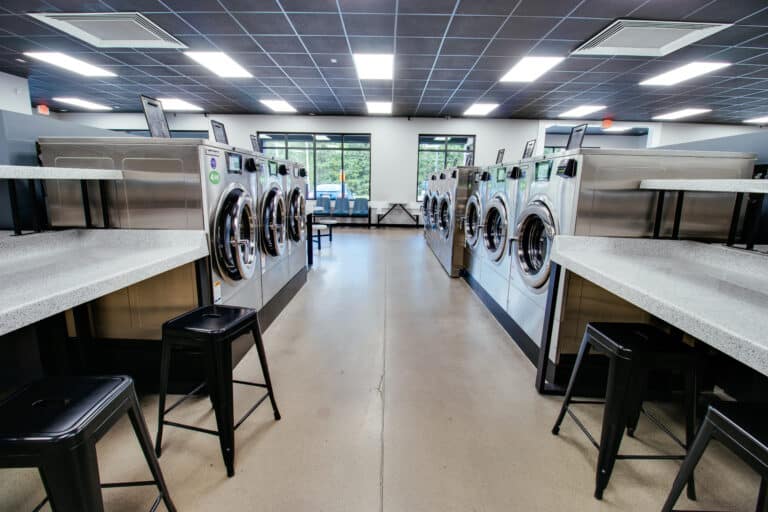 Spacious self-service laundromat in Georgia featuring modern washers, folding stations, and seating at Peanut’s Laundry